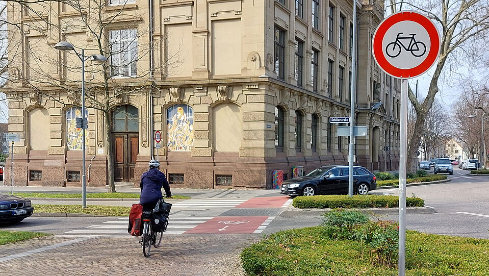 Ein Schild sagt mehr als tausend Worte: Durchfahrt für Fahrräder verboten. Eine Radlerin überquert die Ettlinger Schillerstraße in der falschen Richtung