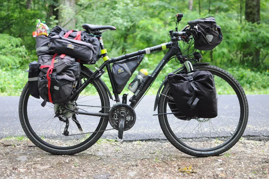 ein mit zahlreichen Taschen beladenes Fahrrad Foto eines Fahrrads, das mit Taschen hinten, vorn und am Lenker beladen ist