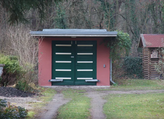 Foto einer einzeln stehenden Garage, die zurückgesetzt in einem Grundstück steht